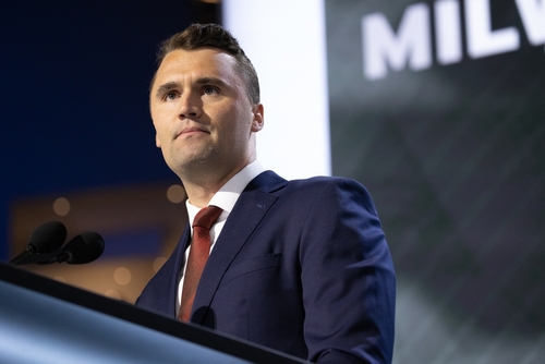shutterstock_2519820055.jpg A man in a suit speaking at a podium during a conference