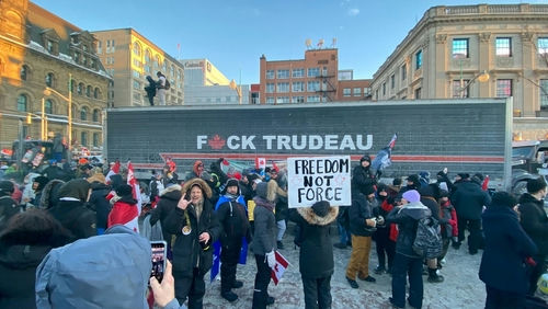 shutterstock2115731321-1jpg Protestors with anti-Trudeau signs in a snowy urban setting.