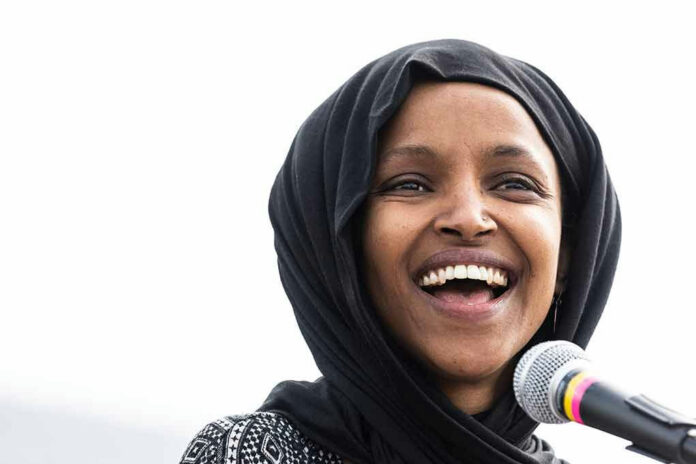1369296272 Smiling woman in hijab speaking into a microphone.