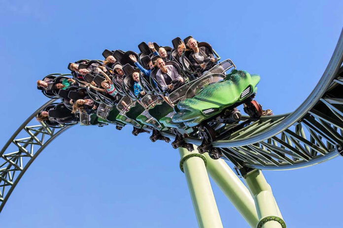 664913563 People on a rollercoaster during a loop.