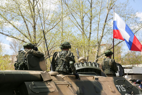 shutterstock_1109265296 Soldiers on an armored vehicle with a national flag