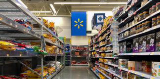 View of a grocery aisle in Walmart with a shopping cart in the foreground