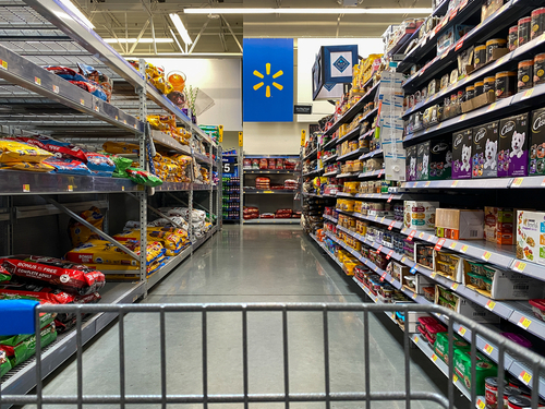 shutterstock_1640845099.jpg View of a grocery aisle in Walmart with a shopping cart in the foreground