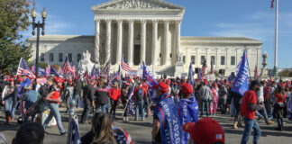 People gathered with flags in front of building
