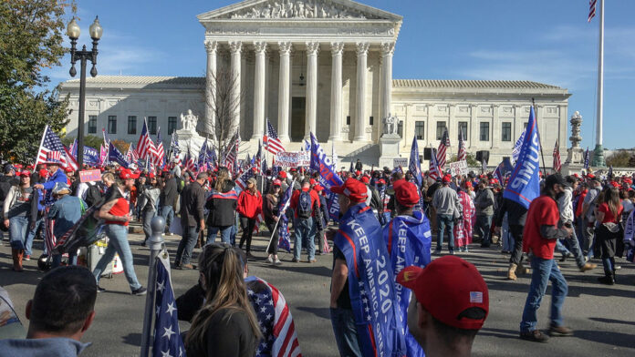 shutterstock_1867993270 People gathered with flags in front of building