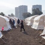 Israel’s Gaza STRIKE: Unanswered Questions A temporary shelter area with tents and people walking around