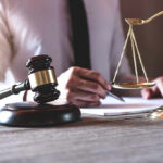 Court Exposes Chilling Online Death Network Gavel and scales beside a person writing.