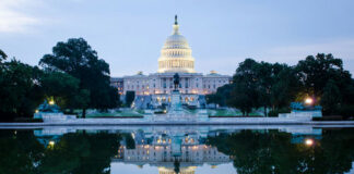United States Capitol building reflected in a calm pool at dusk