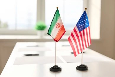 shutterstock_2765360161 Mini flags of Iran and the United States on a conference table