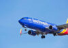 Jet aircraft in flight against clear blue sky.