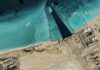 Satellite view of coastal industrial complex with turquoise water