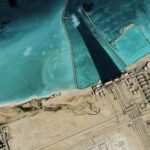 Satellite view of coastal industrial complex with turquoise water