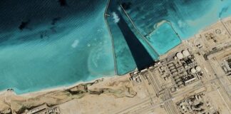 Satellite view of coastal industrial complex with turquoise water