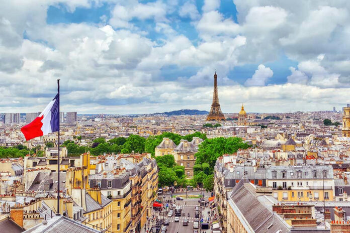 Eiffel Tower view with French flag and cityscape.