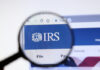Magnifying glass over IRS website logo.