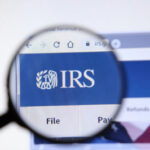 Major Tax: Safety Net Programs Face Historic Cuts Magnifying glass over IRS website logo.