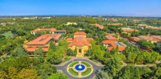 Aerial view of a university campus with central fountain and red-tiled buildings