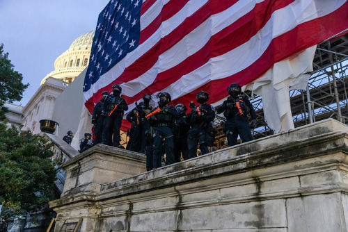 shutterstock_1889190640 Police in riot gear near U.S. Capitol building.