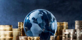 Glass globe surrounded by stacks of gold coins.