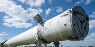 Falcon 9 first stage booster displayed outdoors on support stands