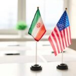 Sanctions Dispute Fuels New Questions About U.S Mini flags of Iran and the United States on a conference table