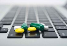 Pills scattered on a laptop keyboard.