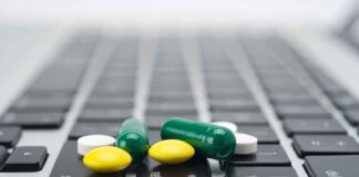 Pills scattered on a laptop keyboard.