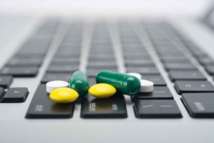 Pills scattered on a laptop keyboard.