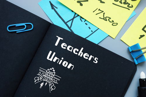 Notebook labeled Teachers Union with office supplies.