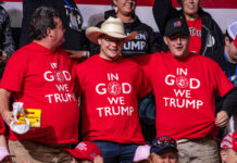 Three men wearing "In God We Trump" shirts.