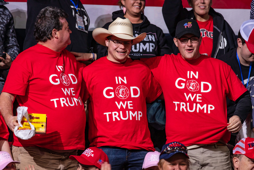 Three men wearing "In God We Trump" shirts.