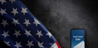 U.S. flag and phone displaying "Election Day" voting message.