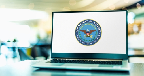 Laptop displaying Department of Defense logo on the screen.